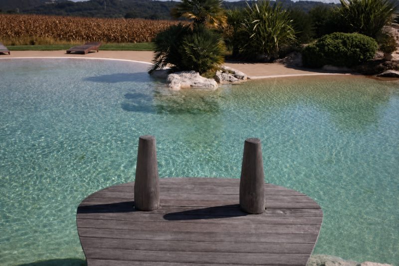 Ponton de bois à deux pieux, posé au-dessus d’une eau turquoise peu profonde